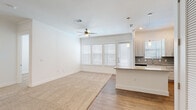 Located at 3030 Greenbusch Rd in Katy, TX, this single-story 2-bedroom, 2-bathroom home offers a thoughtfully designed open-concept layout with clean, modern finishes throughout. The living and kitchen area form the heart of the home, where wood-look flooring transitions seamlessly from the kitchen to carpeted living space. The kitchen is anchored by a granite-topped island with pendant lighting overhead, complemented by light wood cabinetry, a subway tile backsplash, granite countertops, and a stainless steel sink. A ceiling fan and a bank of windows with blinds fill the space with natural light and provide access to the exterior. Both bedrooms feature plush carpet flooring, white walls, and windows with blinds that invite natural light. The primary bedroom is a generous size and includes a spacious walk-in closet with built-in shelving and hanging rods. A second closet offers additional storage. The primary bathroom impresses with a dual-sink vanity featuring granite counters, light wood cabinetry, wood-look flooring, and a glass-enclosed shower with bold dark tile. The secondary bathroom offers a full tub-shower combination with striking large-format dark tile surround and wood-look flooring. A connecting hallway ties all rooms together for a functional and cohesive flow.