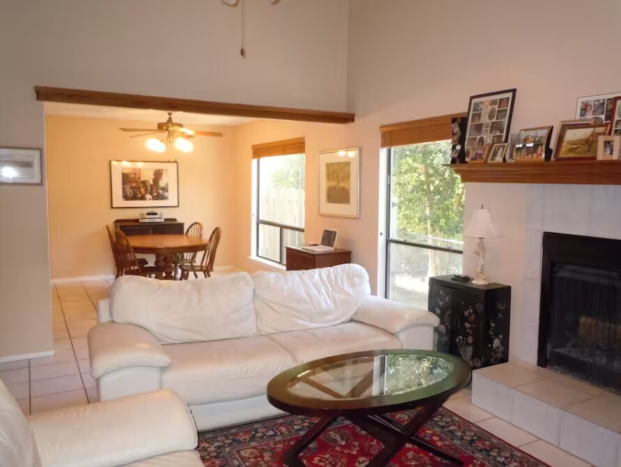 La sala de estar tiene un techo alto con mucha luz natural, chimenea a gas y estantería empotrada. - 6806 Thorncliffe Dr