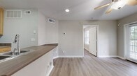 Located at Polo Park in Nashville, TN, this 410-square-foot, one-bedroom, one-bathroom apartment offers a practical and well-appointed living space on a single floor. Light wood-style flooring flows consistently throughout the unit, creating a cohesive and modern aesthetic.

The kitchen is efficiently designed with warm-toned wood cabinetry, stainless steel appliances including a refrigerator, electric range, and over-the-range microwave, complemented by a peninsula with countertop seating that separates it from the living area. A stainless steel sink and ample upper cabinet storage add to the kitchen's functionality.

The 110-square-foot bedroom is bright and airy, featuring a ceiling fan, neutral gray walls, and a window with blinds that allows natural light. A dedicated walk-in closet with built-in shelving and hanging rods provides organized storage space.

The bathroom includes a full-size soaking tub and shower combo, toilet, and grab bars, finished with light flooring that mirrors the rest of the unit. Clean white fixtures and neutral wall tones keep the space feeling fresh and functional.

Throughout the apartment, consistent neutral tones, white trim, and light flooring create a clean, move-in-ready environment suited for comfortable Nashville living.