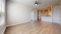 Located at 4555 Grove Springs Cir in Apopka, FL, this 730-square-foot single-floor unit offers a thoughtfully designed layout comprising one bedroom, a combined kitchen and living room, and a closet. Light wood-look flooring runs consistently throughout the unit, lending a clean, cohesive aesthetic.

The open-concept kitchen and living area serves as the heart of the home. The kitchen is equipped with stainless steel appliances—including a side-by-side refrigerator with ice maker, electric range, over-the-range microwave, and dishwasher—alongside crisp white upper cabinetry, gray lower cabinets, a white quartz countertop, and a subway tile backsplash. A peninsula with an undermount sink and matte black faucet provides additional prep space and casual seating. Mason jar-style pendant lights hang above, adding a modern-rustic touch. Built-in open shelving adjacent to the kitchen adds display and storage versatility.

The living room features a ceiling fan with light fixture and flows seamlessly from the kitchen. The 180-square-foot primary bedroom offers generous natural light through large windows with blinds, a ceiling fan, and access to a dedicated closet. Neutral gray walls and clean white trim complete the bright, contemporary feel of this well-appointed unit.