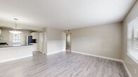 Located at 14566 Seaford Cir in Tampa, FL, this single-story, one-bedroom, one-bathroom unit offers a well-organized layout designed for comfortable everyday living. Light-toned wood-style flooring flows throughout, complementing the neutral beige walls and crisp white trim found in every room.

The open-concept kitchen and living area forms the heart of the unit. The kitchen is equipped with white cabinetry, speckled granite-look countertops, stainless steel appliances including a range, microwave, and refrigerator, and a sink with a window view. Ample storage is provided by two closets situated near the kitchen. The living area is bright and spacious, with a large window allowing natural light to fill the room and a front entry door.

The bedroom is a generously sized private retreat featuring a wide sliding double-door closet and neutral walls that offer a calm, restful atmosphere. A hallway connects the main living spaces to the bedroom and bathroom. The bathroom includes a full tub-shower combination with white tile surround, a white vanity with sink, and a framed mirror. The unit also includes access to a patio, providing outdoor space. Textured ceilings are found throughout the home.
