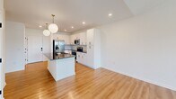 Located at 720 River Hwy in Mooresville, NC, this well-designed one-bedroom, one-bathroom residence offers a thoughtfully organized single-floor layout that maximizes both function and style. The open-concept kitchen and living area serves as the heart of the home, where crisp white shaker cabinetry, dark granite countertops, a subway tile backsplash, and a full suite of stainless steel appliances create a clean, modern aesthetic. A central island with an undermount sink and globe pendant lighting above adds both workspace and visual appeal. Light hardwood flooring runs throughout the main living areas, complementing the bright, white walls and recessed lighting that keep the space feeling open and airy. The living room benefits from abundant natural light through large windows and a glass door that opens to a private balcony, offering outdoor views of the surrounding neighborhood. The bedroom features plush carpeting, a ceiling fan, and generous windows that invite natural light, while a dedicated closet provides practical storage. The bathroom continues the home's cohesive design with white cabinetry, dark hardware accents, dark countertops, and hardwood-style flooring. A dedicated closet rounds out this efficiently designed and move-in-ready residence.
