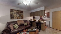 Located at 1796E E Parkshore Dr in Fayetteville, Arkansas, this single-floor residence offers a well-organized and functional layout designed for comfortable everyday living. The open-concept living area serves as the heart of the home, featuring soft carpeting, a textured ceiling, and a ceiling fan that provides both comfort and light. The space flows naturally into a kitchen bar with seating, creating an inviting area for casual dining and entertaining. The galley-style kitchen is thoughtfully designed with ample warm wood cabinetry lining both walls, generous counter space, a full suite of white appliances including a range and refrigerator, and tile flooring. The bedroom is a cozy retreat with plush carpet, a ceiling fan, a natural light-admitting window, and a closet for storage. The bathroom features tile flooring, a vanity with wood cabinetry, a wall mirror, and clean, classic fixtures. Throughout the residence, a warm and cohesive earthy color palette unifies the spaces, complemented by textured walls and practical finishes. The efficient floor plan makes excellent use of every area, offering a comfortable and well-connected living environment in a residential Fayetteville neighborhood.