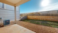 Located at 5702 Melrose Ave in San Angelo, TX, this thoughtfully designed one-bedroom, one-bathroom unit offers a modern aesthetic across a single floor. The open-concept living area seamlessly connects the dining room, kitchen, and living space, creating an efficient and inviting layout. The kitchen is a standout feature, boasting gray shaker-style cabinetry, a bold geometric black-and-white tile backsplash, stainless steel appliances including a range, microwave, refrigerator, and dishwasher, and a central island with a clean white countertop illuminated by pendant lighting. Light wood-style flooring runs throughout the unit, complementing the bright, neutral color palette. The bedroom receives ample natural light through a large window and is equipped with a ceiling fan and a walk-in closet accessed via a sliding barn door. The bathroom features a long vanity with ample storage, a mirror cabinet, and a soaking tub. Additional conveniences include an in-unit laundry area and a covered private patio with a fully fenced yard, offering outdoor space under the open Texas sky.