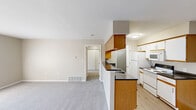 Located at 3100 Old Providence Ln in Columbus, OH, this one-bedroom, one-bathroom unit offers a thoughtfully organized single-floor layout. The combined kitchen and living area forms the heart of the home, with the two spaces flowing seamlessly together. The galley-style kitchen is well-equipped, featuring dark countertops, a double-basin sink, white appliances including a refrigerator, electric range, and built-in microwave, and an abundance of oak-trimmed cabinetry on both sides for generous storage. A peninsula counter with matching dark countertop separates the kitchen from the carpeted living area, providing an ideal spot for casual dining or meal prep. The living area is finished with neutral-toned walls and plush carpet, creating a warm and comfortable atmosphere. The bedroom is a well-proportioned retreat, carpeted throughout and filled with natural light from a large window with blinds. A dedicated closet provides practical storage. The bathroom includes a full tub-shower combination, a single-sink vanity with a mirror, and wood-look flooring. A hallway connects all areas efficiently, completing this functional and comfortable layout.