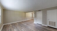 Located at 250 Crumps Park Ave in Macon, Georgia, this two-story home offers a practical and well-appointed layout spread across two floors. The main level houses two living areas, a kitchen, and a hallway, while the upper level accommodates both bedrooms, the bathroom, and a staircase connecting the floors.

Throughout the home, durable luxury vinyl plank flooring in warm wood tones provides a consistent and modern aesthetic. Neutral taupe wall tones complement the clean white trim and baseboards, creating a cohesive and inviting palette. Ceiling fans are featured in multiple rooms, enhancing comfort year-round.

The main-level living spaces are bright and open, with crown molding and textured ceilings adding a classic touch. Natural light flows in through white-trimmed windows fitted with blinds. The kitchen features white cabinetry, light granite-style countertops, and includes a full-size refrigerator, with a closet providing additional storage.

Upstairs, the generously sized primary bedroom offers ample space, a ceiling fan, and two windows that invite natural light. The second bedroom also features a ceiling fan and a window with outdoor views. The shared bathroom is clean and functional, with wainscoting, a window for natural ventilation, and updated fixtures.