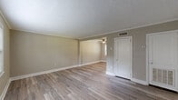 Located at 250 Crumps Park Ave in Macon, Georgia, this two-story home offers a practical and well-appointed layout spread across two floors. The main level houses two living areas, a kitchen, and a hallway, while the upper level accommodates both bedrooms, the bathroom, and a staircase connecting the floors.

Throughout the home, durable luxury vinyl plank flooring in warm wood tones provides a consistent and modern aesthetic. Neutral taupe wall tones complement the clean white trim and baseboards, creating a cohesive and inviting palette. Ceiling fans are featured in multiple rooms, enhancing comfort year-round.

The main-level living spaces are bright and open, with crown molding and textured ceilings adding a classic touch. Natural light flows in through white-trimmed windows fitted with blinds. The kitchen features white cabinetry, light granite-style countertops, and includes a full-size refrigerator, with a closet providing additional storage.

Upstairs, the generously sized primary bedroom offers ample space, a ceiling fan, and two windows that invite natural light. The second bedroom also features a ceiling fan and a window with outdoor views. The shared bathroom is clean and functional, with wainscoting, a window for natural ventilation, and updated fixtures.