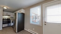 Located at 1245 Granby in Chicopee, Massachusetts, this three-floor property offers a practical and well-maintained layout across its levels. The main living area welcomes you with durable hardwood-style flooring, neutral-toned walls, and multiple windows fitted with blinds that allow natural light to fill the space. A wall-unit air conditioner and baseboard heating provide year-round climate control, while a staircase with a white railing connects the floors seamlessly.

The kitchen is outfitted with white shaker-style cabinetry, granite-look countertops, and a full suite of stainless steel appliances, including a refrigerator, electric range, and dishwasher. An exterior door in the kitchen provides convenient access. Adjacent to the kitchen is a bathroom featuring a white vanity and a well-lit mirror.

The upper level hosts multiple bedrooms, each carpeted and finished with neutral paint tones. The bedrooms are generously sized, with several offering closet space — including a sliding-door and a bi-fold-door closet — and windows that bring in natural light. A bathroom on this level is finished with marble-style tile flooring and wall surround, adding an elevated touch.

The basement level is unfinished, presenting significant potential for additional storage or future development, and is accessible via a painted staircase.