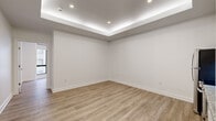 Located at 10 Dorrance Street in the heart of downtown Providence, Rhode Island, this thoughtfully renovated single-floor unit offers a clean, contemporary aesthetic throughout. Light wood-tone luxury vinyl plank flooring runs seamlessly across the entire space, complementing the bright white walls and crisp trim work.

The open living area features a distinctive tray ceiling with integrated LED cove lighting, recessed downlights, and a smooth, modern finish that adds architectural dimension. Adjacent to the living space is a well-appointed kitchen equipped with white shaker-style cabinetry, granite-look countertops, a stainless steel appliance suite including a range, dishwasher, refrigerator, and built-in microwave, and a clean tile backsplash.

The bedroom area is generously sized and benefits from large, floor-to-ceiling windows that invite abundant natural light and offer views of the surrounding urban streetscape. Multiple sliding-door closets provide ample organized storage with built-in hanging rods.

The bathroom is finished with classic white subway tile wainscoting, hexagonal mosaic floor tile, a granite-topped white vanity with brushed gold fixtures, tall upper cabinetry for storage, and a full shower-tub combination. The overall design is cohesive, modern, and move-in ready.