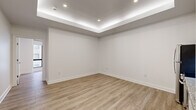 Located at 10 Dorrance Street in the heart of downtown Providence, Rhode Island, this thoughtfully renovated single-floor unit offers a clean, contemporary aesthetic throughout. Light wood-tone luxury vinyl plank flooring runs seamlessly across the entire space, complementing the bright white walls and crisp trim work.

The open living area features a distinctive tray ceiling with integrated LED cove lighting, recessed downlights, and a smooth, modern finish that adds architectural dimension. Adjacent to the living space is a well-appointed kitchen equipped with white shaker-style cabinetry, granite-look countertops, a stainless steel appliance suite including a range, dishwasher, refrigerator, and built-in microwave, and a clean tile backsplash.

The bedroom area is generously sized and benefits from large, floor-to-ceiling windows that invite abundant natural light and offer views of the surrounding urban streetscape. Multiple sliding-door closets provide ample organized storage with built-in hanging rods.

The bathroom is finished with classic white subway tile wainscoting, hexagonal mosaic floor tile, a granite-topped white vanity with brushed gold fixtures, tall upper cabinetry for storage, and a full shower-tub combination. The overall design is cohesive, modern, and move-in ready.