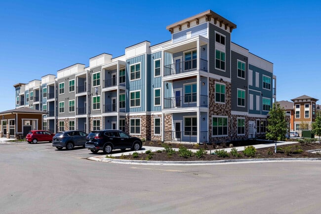 Garrett Parker's three story residential buildings combine stone, siding, and paneled accents across a landscaped community in Parker, CO. - Garrett Parker