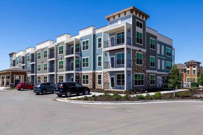 Los edificios residenciales de tres plantas de Garrett Parker combinan piedra, revestimiento y detalles de paneles en una comunidad ajardinada en Parker, Colorado. - Garrett Parker