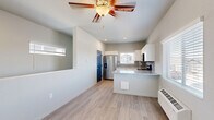 Located in Pueblo, CO, this two-story, 2-bedroom, 2-bathroom home offers a well-organized layout spread across two levels. The main living level hosts an open-concept kitchen and living area finished with light wood-look flooring and a ceiling fan overhead. The kitchen is thoughtfully designed with white cabinetry, granite countertops, a tile backsplash, stainless steel appliances including a French door refrigerator, electric range, and microwave, plus a peninsula that adds additional prep and serving space. Natural light filters in through window blinds, brightening the space throughout the day. Both bedrooms are carpeted and feature ceiling fans, built-in closets with distinctive blue arched doors, and wall-mounted climate control units. The primary bedroom offers a comfortable footprint with ample closet space. Both bathrooms are outfitted with granite vanity tops, white cabinetry, and large mirrors. One bathroom includes a full tub-shower combo with light wood-look flooring, while the other features built-in shelving. Additional conveniences include three closets, an in-unit laundry area, and carpeted staircases connecting the two floors. The clean, neutral palette throughout gives the home a bright, move-in-ready feel.