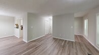 Located in Sandy Springs, GA, this 3-bedroom, 2-bathroom residence offers a thoughtfully laid-out single-floor plan with a clean, neutral aesthetic throughout. Wood-style flooring runs consistently across the living areas, dining room, and bedrooms, lending a cohesive and modern look. The living room serves as the focal point of the home, featuring a classic fireplace with a dark surround and sliding glass doors that open to a private balcony, filling the space with natural light and outdoor views. Adjacent to the living room, the dining area is accented by a multi-bulb chandelier, providing warm, functional lighting. The kitchen is well-appointed with white raised-panel cabinetry, dark granite-style countertops, stainless steel appliances including a gas range and dishwasher, and a double-basin sink. The primary bedroom offers generous proportions and a large window overlooking greenery. The two bathrooms are finished with white vanity cabinetry, dark countertops, and tub-shower combinations with chrome fixtures. Additional bedrooms provide comfortable, light-filled spaces with ample room for varied use. A hallway and dedicated closet round out the practical layout of this well-maintained Sandy Springs residence.