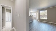 Located at 6969 Hollister St in Houston, TX, this one-bedroom, one-bathroom residence offers a thoughtfully designed single-floor layout with a clean, modern aesthetic. Light gray walls, crisp white trim, and wood-look luxury vinyl plank flooring flow throughout the main living areas, creating a cohesive and contemporary look.

The entry hallway opens into a well-appointed kitchen featuring white shaker-style cabinetry, light granite-look countertops, a subway tile backsplash, stainless appliances, and a peninsula that overlooks the adjoining living area. The living room benefits from multiple windows that invite abundant natural light and offer views of the surrounding greenery.

The spacious bedroom is finished with plush carpeting, a ceiling fan, and a generously sized window framing outdoor views. Two closets serve the bedroom, including a walk-in closet outfitted with wire shelving that provides ample storage. The bathroom is well-equipped with a wide vanity topped with light stone counters, a large mirror with bright overhead lighting, and a tub-shower combination. Tile flooring in the bathroom complements the overall neutral palette. A dedicated hallway connects all rooms efficiently, rounding out this well-organized and functional floor plan.