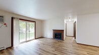 This 2-bedroom, 1-bathroom unit in Madison, Wisconsin offers a practical and well-appointed single-floor layout. Throughout the home, warm-toned hardwood-style flooring and rich dark wood trim create a cohesive, inviting aesthetic against clean white walls.

The galley-style kitchen is efficiently designed with ample light wood cabinetry, granite countertops, a double-basin sink, and black appliances including a range and refrigerator. It flows directly into a dining area equipped with a ceiling fan overhead.

The spacious living room features a wall-mounted air conditioning unit, a baseboard heating system, and a sliding glass door that opens to a private balcony with pleasant outdoor views of mature trees — bringing in an abundance of natural light.

The primary bedroom is generously sized, offering a sliding double-door closet and a window with green outdoor views, along with baseboard heating. The second bedroom is a comfortable, well-lit space with its own window and closet access. Both bedrooms share the same consistent flooring and neutral color palette found throughout the unit.

The layout is efficient and functional, making excellent use of the available space, and is well-suited for those seeking a comfortable, move-in-ready home in Madison, WI.