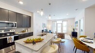 This 1-bedroom, 1-bathroom residence in Santa Ana offers a thoughtfully designed single-floor layout that maximizes both comfort and functionality. The open-concept living and kitchen area serves as the heart of the home, where a spacious granite-topped island with an undermount sink and pendant lighting anchors the space. The kitchen is outfitted with dark espresso cabinetry, a subway tile backsplash, and a full suite of stainless steel appliances, including a refrigerator, range, microwave, and dishwasher. Wood-style flooring flows throughout the main living areas, adding warmth and continuity. The living room receives generous natural light through large windows and a glass door that leads to an outdoor area. The bedroom is a serene retreat featuring plush carpeting, a ceiling fan, and multiple windows that fill the room with daylight. The full bathroom is elegantly appointed with dark cabinetry, granite countertops, a large vanity mirror, and a full tub-shower combination with tile surround. Clean white walls and recessed lighting throughout the residence create a bright, modern ambiance that is both inviting and versatile.