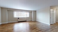 Located at 515 Mt Prospect Ave in Newark, NJ, this single-floor unit offers a clean, modern aesthetic throughout. The open living and dining areas are finished with warm hardwood-style flooring that extends seamlessly across the space, complemented by neutral taupe walls and crisp white trim. Large windows fitted with blinds invite generous natural light while offering views of the surrounding neighborhood. Baseboard heating units are present throughout, ensuring year-round comfort.

The kitchen is a standout feature, showcasing dark espresso-toned cabinetry with brushed nickel hardware, stone-look granite countertops, a decorative tile backsplash in a geometric pattern, a stainless steel sink, and stainless steel appliances. The layout connects efficiently to the main living areas via a bright, welcoming entryway hallway.

A dedicated bedroom area provides a comfortable retreat, complete with a closet and its own window overlooking greenery outside. The bathroom is clean and functional, featuring white subway-style wall tiles, a soaking tub with overhead shower, white tile flooring, and a dark wood vanity with chrome fixtures. The overall ambiance of the unit is bright, neutral, and move-in ready.