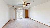 Located at 830 Roberts Rd in Sartell, Minnesota, this single-floor unit offers a thoughtfully designed layout that balances comfort and practicality. The open-concept living area features plush carpeting, warm wood baseboards, and a ceiling fan with light fixture, creating a welcoming atmosphere. Sliding glass doors lead to a private balcony, filling the space with natural light and offering pleasant views of the surrounding grounds.

The kitchen is efficiently designed with warm-toned wood cabinetry, black appliances including a refrigerator and range, recessed lighting, and durable laminate flooring. A peninsula with a built-in sink and light-toned countertop provides a seamless transition between the kitchen and living space.

The bedrooms are generously sized, each featuring soft carpeting, wood-trimmed doors, and ample closet space. Natural light flows in through sizable windows, providing views of the neighborhood. The bathroom is well-appointed with a rich wood vanity, white countertop, a large mirror with overhead lighting, and tile flooring that adds a classic touch.

A dedicated laundry area with a full-size washer and dryer and overhead shelving adds everyday convenience. Throughout the unit, consistent warm wood trim and neutral tones create a cohesive, inviting aesthetic.