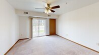 Located at 830 Roberts Rd in Sartell, Minnesota, this single-floor unit offers a thoughtfully designed layout that balances comfort and practicality. The open-concept living area features plush carpeting, warm wood baseboards, and a ceiling fan with light fixture, creating a welcoming atmosphere. Sliding glass doors lead to a private balcony, filling the space with natural light and offering pleasant views of the surrounding grounds.

The kitchen is efficiently designed with warm-toned wood cabinetry, black appliances including a refrigerator and range, recessed lighting, and durable laminate flooring. A peninsula with a built-in sink and light-toned countertop provides a seamless transition between the kitchen and living space.

The bedrooms are generously sized, each featuring soft carpeting, wood-trimmed doors, and ample closet space. Natural light flows in through sizable windows, providing views of the neighborhood. The bathroom is well-appointed with a rich wood vanity, white countertop, a large mirror with overhead lighting, and tile flooring that adds a classic touch.

A dedicated laundry area with a full-size washer and dryer and overhead shelving adds everyday convenience. Throughout the unit, consistent warm wood trim and neutral tones create a cohesive, inviting aesthetic.