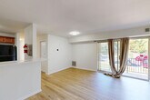 Located in Hyattsville, MD, this single-floor residence offers four bedrooms and two bathrooms within a well-organized, functional layout. Light hardwood flooring flows consistently throughout the home, creating a bright and cohesive aesthetic. The open living and dining area is a standout feature, bathed in natural light from large sliding glass doors that lead directly to a private balcony with outdoor views — ideal for everyday relaxation. The kitchen is well-appointed with warm honey-toned wood cabinetry, white countertops, a vibrant teal subway tile backsplash, and black appliances including a gas range, dishwasher, refrigerator, and built-in microwave. A pass-through counter connects the kitchen to the living area, enhancing the open feel. The four bedrooms are bright and cleanly finished, each with light walls and hardwood floors; several feature windows with outdoor views and closets with louvered doors. The home also includes five closets total for ample storage, a dedicated laundry area, and a dining space. The overall ambiance is clean, functional, and move-in ready, with a neutral palette that offers flexibility for any style of furnishing.
