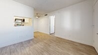 Located at 4722 E Bell Rd in Phoenix, AZ, this efficient one-bedroom, one-bathroom unit offers a well-designed single-level layout making smart use of every square foot. Throughout the space, light wood-look luxury vinyl flooring creates a warm, cohesive aesthetic, complemented by crisp white walls and clean white baseboards.

The combined kitchen and living area forms the heart of the unit. The kitchen features two-tone cabinetry — white upper cabinets paired with dark lower cabinets — along with light countertops and a full suite of stainless steel appliances, including a refrigerator, electric range, and over-the-range microwave. A pass-through opening connects the kitchen to the living area, enhancing the open feel. A ceiling fan overhead adds both function and comfort.

The living area is bright and open, with a clean, neutral palette that provides a versatile backdrop. The bedroom receives natural light through a window fitted with horizontal blinds, contributing to an airy atmosphere. The bedroom also features a dedicated entry door and the same consistent flooring found throughout.

The bathroom is finished in white with a full tub-and-shower combination, a toilet, and a vanity, maintaining the unit's clean, modern aesthetic. A utility room rounds out the floor plan. Textured ceilings are present throughout, adding subtle architectural character to this well-maintained Phoenix residence.