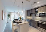 Located in Doral, FL, this thoughtfully designed single-floor residence offers a seamless blend of modern aesthetics and functional living. The open-concept layout connects the kitchen, dining, and living areas into one cohesive, light-filled space. The kitchen is a standout feature, showcasing wood-toned cabinetry, a mosaic tile backsplash, granite countertops, stainless steel appliances, and a central island with bar seating — ideal for both casual dining and entertaining. Track and pendant lighting add a polished finishing touch overhead.

The living area is bright and welcoming, with light wood-style flooring flowing throughout, a ceiling fan, and large sliding glass doors that open to a private balcony overlooking lush tropical greenery. The bedrooms are serene retreats, carpeted for comfort and filled with natural light through generously sized windows. Each bedroom features a ceiling fan and soft, neutral tones that promote a relaxed atmosphere.

The bathroom is elegantly appointed with a walk-in glass-enclosed shower finished in large-format tile, a granite double vanity, and wood-toned cabinetry that complements the overall design palette. Throughout the residence, clean lines, contemporary finishes, and an abundance of natural light create a cohesive and inviting ambiance.