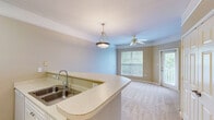 Located at 7000 Johnson Farm Ln in Chadds Ford, PA, this one-bedroom, one-bathroom residence offers a thoughtfully organized single-floor layout. The open-concept living and kitchen area serves as the heart of the home, where a curved breakfast bar counter creates a natural divide between the two spaces while encouraging an airy, connected feel. The kitchen is equipped with white cabinetry, a coil-burner electric range, and a full-size refrigerator, all set atop light-toned tile flooring that lends a clean, bright aesthetic.

The living area transitions seamlessly via plush wall-to-wall carpeting, which continues into the bedroom. The bedroom is a well-proportioned private retreat featuring large windows dressed with blinds that invite ample natural light and views of the surrounding greenery. A dedicated walk-in closet off the bedroom provides practical storage with built-in wire shelving and hanging rods.

The bathroom is finished with light tile flooring, a white vanity with under-sink storage, a mirrored medicine cabinet, and a well-lit vanity fixture overhead. Warm neutral tones carry throughout the entire residence, contributing to a cohesive and calm ambiance. A private entry with access to an outdoor area completes this efficiently designed home in a serene Chadds Ford setting.