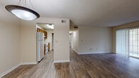 This single-story residence in LaGrange, Georgia offers a functional and well-organized layout with consistent wood-look flooring running throughout every room. The open living and dining area is a central highlight, featuring a pendant light fixture, neutral walls, and a sliding glass door that brings in natural light and provides outdoor access. A separate living room extends the common space, offering room for flexible furniture arrangements.

The galley-style kitchen is equipped with warm-toned wood cabinetry lining both walls, white appliances including a refrigerator and electric range, a double sink with a dishwasher, and light countertops that provide ample prep space. A pass-through opening connects the kitchen to the rest of the living areas, promoting an open feel.

The bedrooms are bright and simply finished, with neutral walls, wood-look flooring, and windows fitted with blinds that allow natural light while maintaining privacy. One bedroom includes access to a utility closet. The full bathroom features warm wood cabinetry, a wide vanity with a single sink, a large mirror, and a tub-shower combination. Textured ceilings and crisp white trim are consistent throughout, giving the space a clean and cohesive appearance.