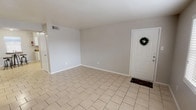 This single-floor, 2-bedroom, 1-bathroom home offers a clean, functional layout with light-toned tile flooring extending throughout every room, creating a cohesive and easy-to-maintain interior. The open living area welcomes you through a front entry door and features neutral gray walls, white baseboards, and ample room for comfortable furnishings. Natural light filters in through blinds-equipped windows, adding brightness to the space.

The kitchen is well-appointed with white cabinetry, dark granite-style countertops, and a full suite of stainless steel appliances including a refrigerator, electric range, and dishwasher. A double-basin sink and a window above the counter contribute to both functionality and natural light in this work space.

Both bedrooms are generously sized, each featuring ceiling fans with light fixtures and windows that allow for natural ventilation and light. One bedroom includes direct access to a closet and additional doorways for convenient connectivity within the home.

The bathroom is neatly finished with tile flooring, a tub-shower combination, a vanity with storage, and a window for ventilation. The overall design of this home is straightforward and practical, with a neutral palette that provides a versatile backdrop for a variety of living arrangements.
