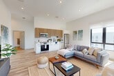 This thoughtfully designed 2-bedroom, 2-bathroom residence in Haverhill, MA offers a bright, modern living experience across a well-appointed single floor. The open-concept living, dining, and kitchen area serves as the heart of the home, featuring soaring ceilings, recessed lighting, and large black-framed windows that flood the space with natural light and frame scenic outdoor views. Light wood-tone flooring flows consistently throughout, enhancing the airy, cohesive aesthetic.

The kitchen is outfitted with stainless steel appliances, white lower cabinetry, warm wood upper cabinets, and a classic white subway tile backsplash. The living area offers generous room to relax and entertain.

Both bedrooms are well-sized and bright, with large windows providing natural light and outdoor views. The primary bedroom includes a dedicated closet and connects to its own bathroom. The second bedroom features a barn-style sliding closet door and its own window outlook.

The two bathrooms are finished in a clean, contemporary style with wood-look flooring, white vanities, black hardware accents, and large mirrors. One bathroom includes a glass-enclosed walk-in tile shower. Additional features include multiple closets, in-unit laundry, a utility room, and a hallway connecting all spaces efficiently.