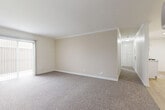 Located at 10566 Hole Ave in Riverside, California, this single-story 2-bedroom, 2-bathroom home offers a well-organized layout designed for comfortable everyday living. The living room is generously proportioned, featuring warm neutral-toned walls, crown molding, plush carpeting, and a sliding glass door fitted with vertical blinds that allows natural light to fill the space. A ceiling fan adds to the comfort of the main living area. The galley-style kitchen is outfitted with white cabinetry, brushed nickel hardware, a stainless steel sink, gas range, and light hardwood-style flooring — providing a clean, functional workspace. Both bedrooms are carpeted and bright, each featuring windows with vertical blinds that filter natural light. The primary bedroom offers a comfortable footprint with a dedicated closet. The two bathrooms include a full bath with a tiled tub-shower surround and a window for ventilation, as well as a second bath featuring a white vanity with a countertop sink and hardwood-style flooring. Clean white walls and consistent finishes throughout give the home a cohesive, move-in ready appearance. Situated in a residential neighborhood in Riverside, this home combines practical design with a straightforward, livable floor plan.