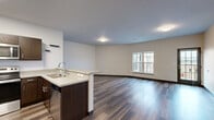 Located at 350 Broadway St in Sheboygan Falls, WI, this well-appointed 3-bedroom, 2-bathroom single-floor residence offers a thoughtfully designed open-concept layout. Rich hardwood-style flooring flows consistently throughout the entire space, complementing the clean, neutral wall tones that create a bright and welcoming atmosphere.

The combined kitchen and living area serves as the heart of the home. The kitchen is outfitted with dark espresso cabinetry, white countertops, a peninsula with a double sink, and a full suite of stainless steel appliances including a refrigerator with ice maker, range, and microwave. The adjacent living area is generously sized and filled with natural light through large windows, with convenient access via a glass-panel exterior door.

The spacious primary bedroom features an oversized multi-pane window with views of the surrounding neighborhood and a large walk-in closet with wire shelving systems for organized storage. Two additional bedrooms offer ample natural light and dedicated closet space. The bathrooms are finished with dark vanity cabinetry and include a glass-enclosed walk-in shower. A dedicated laundry room houses a full-size washer and dryer with overhead wire shelving. A utility room rounds out the functional layout of this modern residence.