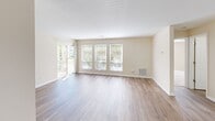 Located at 8799 Old Colony Way in Alexandria, VA, this two-bedroom, one-bathroom unit offers a well-designed single-floor layout with a comfortable and functional living environment. The open-concept living area features light wood-style flooring that flows throughout, with large windows and a sliding glass door that fill the space with natural light and provide access to a private balcony overlooking the surrounding neighborhood. The kitchen is equipped with warm wood cabinetry, dark granite-style countertops, black appliances including an electric range and built-in microwave, and a curved breakfast bar peninsula that connects seamlessly to the dining area. A pendant chandelier adds a refined touch above the dining space. The primary bedroom is generously sized, featuring plush carpeting and dual closets with sliding panel doors, offering ample storage. The second bedroom also features carpet flooring and a large sliding-door closet. The bathroom is clean and straightforward, finished with wood-look flooring and white fixtures. A dedicated laundry room provides added convenience, complete with a full-size washer and dryer and built-in wire shelving for storage. Throughout, neutral warm beige tones create a cohesive and inviting atmosphere.