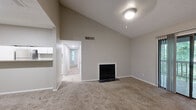 This well-appointed 2-bedroom, 1-bathroom residence offers a thoughtfully designed single-floor layout with a range of notable features. The living room immediately impresses with its dramatic vaulted ceilings and a ceiling fan, creating an open and airy atmosphere. A classic fireplace serves as a focal point, while plush carpeting adds warmth underfoot. Sliding glass doors lead to a private wooden deck overlooking lush, tree-lined surroundings, filling the space with natural light. The kitchen features crisp white cabinetry, granite-look countertops, stainless steel appliances, and a pass-through bar that opens to the living area — ideal for both everyday living and entertaining. The spacious primary bedroom benefits from multiple windows that frame greenery outside, offering a bright and tranquil retreat, along with access to a well-organized walk-in closet with wire shelving. The second bedroom is equally comfortable with its own windows and generous closet space. The full bathroom is clean and functional, featuring a tiled tub-shower combination, wood-look flooring, and a vanity with storage. Two hallways connect the rooms efficiently, and three closets throughout provide ample storage. The entry area transitions from wood-look flooring to carpet, defining a practical foyer space.