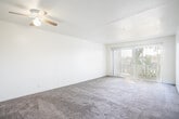 Located at 31108 Brae Burn Ave in Hayward, CA, this single-floor, one-bedroom, two-bathroom unit offers a thoughtfully organized layout across a comfortable footprint. The combined living and dining area is a bright, open space featuring carpet flooring, a ceiling fan with light fixture, and a large sliding glass door with vertical blinds that opens to a private balcony, allowing natural light to fill the room. The kitchen is equipped with dark granite-style countertops, white cabinetry, a stainless steel sink, and includes a refrigerator and range, with a window that brings in additional natural light. Hardwood-style flooring runs through the kitchen and bathrooms, providing a clean contrast to the carpeted living and sleeping areas. The spacious bedroom features a wide sliding-door closet, a window with outdoor views, and ample room for furnishings. Two full bathrooms serve the unit — one features a combined tub and shower with tile surround, a vanity with white cabinetry, and hardwood-style flooring, while the second offers a similar vanity setup. A hallway connects the main areas, with additional closet storage and a dedicated utility room rounding out the practical amenities of this well-structured Hayward residence.