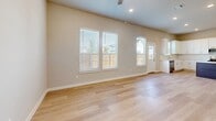 Located at 2205 Kincaid Lane in Melissa, TX, this two-story home offers four bedrooms and four bathrooms across two well-proportioned floors. The ground floor hosts the main living areas, including an open kitchen and living room combination. The kitchen is a standout feature, showcasing crisp white shaker cabinetry, a white subway tile backsplash, quartz countertops, stainless steel appliances, and a central island with a contrasting dark base — all set atop light wood-look flooring that flows throughout the home. A pantry and convenient hallway connections add to the ground floor's functionality, along with an attached garage equipped with an automatic opener and electrical panel access. The upper floor contains all four bedrooms, including a spacious primary suite with a walk-in closet outfitted with built-in shelving and hanging rods. Bedrooms feature vaulted or elevated ceilings, neutral walls, natural light from windows with blinds, and the same warm wood-look flooring. The bathrooms are well-appointed, with at least one featuring a soaking tub surrounded by large-format marble-look tile and chrome fixtures. A pedestal-sink powder bath, multiple closets, and two staircases round out this thoughtfully designed home.