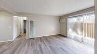 Located at 700 W La Jolla St in Placentia, CA, this single-story, 3-bedroom, 2-bathroom home offers a well-organized layout with consistent, modern finishes throughout. Light wood-style vinyl flooring runs through the main living areas and bedrooms, complementing the neutral warm-gray and beige wall tones that create a cohesive, move-in-ready feel.

The combined kitchen and living room area forms the heart of the home. The kitchen features crisp white shaker-style cabinetry with contemporary bar-pull hardware, granite-look countertops, a stainless steel double sink, and a black gas range with an overhead vent hood. A ceiling fan adds comfort to the open living area, which benefits from a sliding glass door with vertical blinds, inviting natural light and outdoor views.

Three bedrooms offer practical living spaces, each with light flooring, neutral walls, and sliding-door closets providing ample storage. Several bedrooms include large windows with vertical blinds, allowing generous natural light. The primary bedroom includes a full-width double sliding closet.

The two bathrooms are finished with white cabinetry, granite-look countertops, and light flooring. One bathroom includes a dual-mirror vanity and a separate toilet compartment, while the other features a clean, all-white shower/tub enclosure. A central hallway connects all rooms efficiently throughout this compact yet functional home.