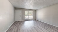 Located at 6230 Rumford Lane in Houston, TX, this single-story, three-bedroom, two-bathroom home offers a practical and comfortable layout. Throughout the home, light wood-look laminate flooring provides a clean, cohesive aesthetic that complements the neutral gray and white wall tones.

The living room serves as the main gathering space, featuring a textured popcorn ceiling, a large window with blinds that invites natural light, and direct access to the front entry. The kitchen is accessed via a pass-through counter with a speckled granite-style surface, and is equipped with white cabinetry, a black refrigerator, and an electric range with overhead ventilation.

The three bedrooms each feature the same light laminate flooring and ceiling fans with light fixtures. The spacious primary bedroom includes a sliding glass door that opens to an outdoor area, while the additional bedrooms benefit from natural light through windowed walls with blinds. Two closets provide convenient storage, including a walk-in style closet with built-in hanging rods.

Both bathrooms are finished with speckled countertops and wood-look flooring. One bathroom features a tub-shower combination with white tile surround, while the second offers a full vanity with a large mirror and a soaking tub with a shower curtain rod.