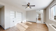 Located at 363 New St in Macon, Georgia, this one-bedroom, one-bathroom unit offers a compact yet well-organized layout across a single floor. The combined living and dining area serves as the heart of the unit, featuring warm wood-look flooring, neutral gray walls, and a ceiling fan with a light fixture that promotes airflow and comfort. A wide window with horizontal blinds fills the space with natural light while framing views of the Macon cityscape. A built-in shelving unit with lower cabinet storage adds functional display and organization space to the living area.

The bedroom continues the same wood-look flooring and neutral palette, with a ceiling fan overhead, windows on two walls for cross-ventilation, and a wall-unit heater. A closet with bifold doors provides dedicated storage.

The kitchen connects seamlessly to the living space and is visible through an open passage, maintaining an open and accessible flow throughout the unit. The bathroom is cleanly appointed with classic white penny tile flooring, a tub-shower combo with white tile surround, a white vanity with black fixtures, and a framed mirror with bar lighting above, creating a crisp, modern aesthetic. Overall, the unit presents a clean, functional design well-suited for efficient urban living.