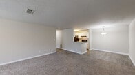 Located at 5200 N Henry Blvd in Stockbridge, GA, this single-floor, one-bedroom, one-bathroom residence offers a well-organized layout designed for comfortable everyday living. The open-concept living and dining area is finished with plush wall-to-wall carpeting and neutral tones throughout, creating a warm and inviting atmosphere. A textured ceiling adds subtle character to the space, while ample wall outlets ensure practical functionality.

The kitchen is a standout feature, offering a galley-style design with white shaker cabinetry, light speckled countertops, a stainless steel sink, and black appliances including a refrigerator, electric range, and dishwasher. Wood-look flooring runs through the kitchen, transitioning seamlessly to the adjacent living area. A peninsula counter connects the kitchen to the living space, enhancing the open feel.

The bedroom is a comfortable, carpeted retreat featuring a ceiling fan, natural light from multiple windows with blinds, and a textured ceiling. A dedicated walk-in closet equipped with wire shelving provides generous storage. The bathroom and additional closet space round out the unit's practical layout, making efficient use of every square foot this residence has to offer.
