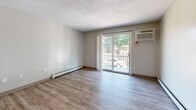 Located at 1500 Sherburne Dr SE in Saint Cloud, Minnesota, this one-bedroom, one-bathroom unit offers a well-organized, single-floor layout designed for comfortable everyday living. The living room is bright and inviting, featuring durable hardwood-style vinyl flooring, a textured ceiling, and a sliding glass door that opens to a private balcony with views of surrounding trees — allowing natural light to fill the space. A wall-mounted air conditioning unit and baseboard heating ensure year-round comfort.

The galley-style kitchen is efficiently laid out with ample white cabinetry reaching toward the ceiling, light stone-look countertops, a stainless steel sink, and black appliances including an electric range, refrigerator, and dishwasher. Hardwood-style flooring continues throughout, tying the space together seamlessly.

The bedroom is a comfortable retreat, carpeted for warmth, and equipped with a ceiling fan, a natural window overlooking the outdoors, and a full-width closet with bi-fold doors for generous storage. Baseboard heating adds to the room's coziness.

The bathroom is clean and classic, featuring a tiled tub-shower combination, mosaic tile flooring, a granite-topped vanity with white cabinetry, and a large mirror. A hallway connects all areas of the home, contributing to its efficient and functional flow throughout.