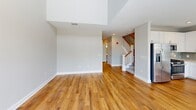 Located at 7131 Arlington Rd in the heart of Bethesda, MD, this well-appointed two-story residence offers 2 bedrooms and 4 bathrooms spread across two thoughtfully designed floors. The main level features warm hardwood flooring throughout, soaring ceilings that lend an open, airy feel, and a bright living room anchored by elegant French doors and a signature arched window that invite abundant natural light and outdoor views. The modern kitchen is outfitted with white shaker cabinetry, quartz countertops, a subway tile backsplash in a soft neutral tone, stainless steel appliances, and a built-in desk nook beneath another arched window. A stylish sliding barn door adds a contemporary touch near the entryway. Upstairs, the two bedrooms are carpeted for comfort, including a generously sized primary suite with its own bathroom. All four bathrooms are finished with clean white fixtures and hardwood or tile flooring. A staircase with a classic wood banister connects the two levels, complemented by hallways that provide smooth transitions throughout. Two closets offer practical storage. The overall aesthetic is clean, neutral, and move-in ready, combining modern finishes with classic architectural details.