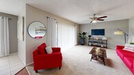 Located at 1475 Woodlake Dr in Lakeland, Florida, this single-floor residence offers a well-organized layout encompassing two bedrooms, one bathroom, an office, and a combined living, dining, and kitchen area connected by a hallway. The living room is generously sized, featuring neutral carpet flooring, a ceiling fan, and a textured ceiling. A large sliding glass door floods the space with natural light and provides an outdoor view, complementing the open, airy feel of the room. The kitchen is functional and efficient, outfitted with rich wood cabinetry, granite-style countertops, tile flooring, and black appliances including a range, dishwasher, and refrigerator. It opens directly into the bright dining area, which benefits from a large window with vertical blinds and is finished with the same light tile flooring. The spacious primary bedroom features plush carpet, a ceiling fan, and ample room for a king-sized bed. The second bedroom is well-proportioned with matching carpet and a ceiling fan. The full bathroom includes a tiled tub-shower combination, tile flooring, and a vanity with storage. An additional office space rounds out this practical and comfortable Lakeland residence.