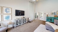 This well-appointed single-floor space offers an expansive and thoughtfully designed layout across a generous footprint. The dramatic entrance sets the tone immediately, featuring soaring vaulted ceilings with skylights, warm wood-look flooring, and large glass double doors that flood the space with natural light and provide open views to the outdoors.

The living area is anchored by a classic brick fireplace with a full-height surround and sliding glass doors that open to an outdoor pool area, seamlessly blending indoor and outdoor living. Adjacent to the living area, the bright and airy dining room is lined with large gridded windows overlooking the pool, creating a light-filled and inviting atmosphere for gatherings around a substantial communal table.

The kitchen is functional and well-equipped, featuring stainless steel appliances, tile backsplash, wood cabinetry, and a charming window above the sink that brings in natural greenery views. A secondary dining area offers hardwood floors, wrap-around windows, and a relaxed, casual ambiance ideal for informal meals or lounge use.

The dedicated exercise room is well-lit with recessed panel lighting, rubberized flooring, mirrored walls, and multiple cardio and strength-training machines. The spacious primary bedroom and additional entrance with mosaic tile flooring and interior pass-through window round out this versatile and highly functional space.