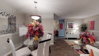 This well-appointed single-floor residence at 4300 Flat Shoals Rd in Union City, Georgia, offers a thoughtfully designed layout with a cohesive, modern aesthetic throughout. The living room serves as the heart of the home, featuring rich hardwood-style flooring, a textured ceiling, and an open feel accentuated by vibrant décor, bold artwork, and a large sectional sofa anchored by a colorful area rug. Natural light filters in through curtained windows, adding warmth to the space. Adjacent to the living area, the dining room centers around a round glass-top table beneath a contemporary pendant light fixture, with wainscoting along the walls lending a classic touch. The kitchen is efficiently designed with white cabinetry, dark granite countertops, black appliances, and a convenient breakfast bar with seating — ideal for casual dining. The bedroom is carpeted and comfortably scaled, offering a ceiling fan, a bright window with outdoor views, and ample room for furnishings. The bathroom features dark granite countertops, white cabinetry with built-in storage, and a tub-shower combination. A dedicated in-unit laundry room with washer and dryer hookups and overhead shelving adds everyday practicality to this move-in-ready home.