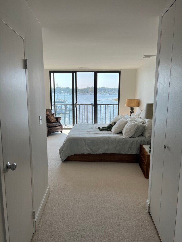 Main bedroom with walk in closet and en suite full bath, balcony, water views and wall mounted tv. - 100 Seaview Ave