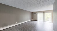 Located at 6242 Corbly St in Cincinnati, Ohio, this single-floor unit offers a well-organized layout with multiple rooms designed for comfortable living. The open living area features durable wood-look vinyl flooring, a textured ceiling, baseboard heating, and a wall-mounted air conditioning unit. Sliding glass doors fitted with vertical blinds lead to a private balcony, filling the space with natural light and providing pleasant outdoor views of surrounding greenery.

The kitchen is a standout feature, equipped with white shaker-style cabinetry, granite-look countertops, a stainless steel sink, and a full suite of stainless steel appliances including a refrigerator, electric range, microwave, and dishwasher. Wood-look vinyl flooring carries through this functional, galley-style kitchen.

The bedrooms are carpeted and finished with neutral-toned walls, textured ceilings, and baseboard heating. Each room benefits from natural light through windows fitted with horizontal blinds, and wall-mounted air conditioning units are present in select rooms.

The bathrooms are clean and modern, each featuring a tub-shower combination with tiled surround, a toilet, and a vanity with granite-look countertops and brushed nickel hardware. Wood-look vinyl flooring completes the contemporary finish throughout these spaces.