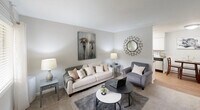 Located at 200 Barnes St in Carrboro, NC, this one-bedroom, one-bathroom residence offers a thoughtfully arranged single-floor layout that makes efficient use of its compact footprint. The living room is bright and welcoming, featuring carpet flooring, a large front-facing window with blinds that invites natural light, and neutral gray walls that create a clean, versatile backdrop. The space comfortably accommodates a seating area, making it ideal for both relaxing and working from home. The kitchen is designed for practicality, featuring white cabinetry, dark countertops, and hardwood-style flooring. It is equipped with black and stainless steel appliances, including a refrigerator, electric range, and over-the-range microwave, all arranged in an efficient galley-style configuration. The bedroom is carpeted and serene, with a textured ceiling, a window allowing soft natural light, and a walk-in closet providing ample storage. The neutral color palette carries throughout, lending a calm and cohesive feel to the room. The bathroom includes a full tub-shower combo with a curtain surround and chrome fixtures, finished in clean white tones. Overall, this residence offers a practical and comfortable living environment well-suited for those seeking a streamlined space in the Carrboro community.
