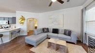 Located in Katy, Texas, this well-appointed single-story home offers two bedrooms and two bathrooms across a comfortable, functional floor plan. The living room sets an inviting tone with crown molding, a ceiling fan, and warm hardwood flooring, flowing naturally into an open entryway filled with natural light from multiple windows. An elegant arched passage connects the main living area to the rest of the home.

The kitchen is outfitted with rich dark cabinetry, light quartz countertops, a subway tile backsplash, and a full suite of stainless steel appliances, including a side-by-side refrigerator, electric range, and built-in microwave. Hardwood flooring and a window overlooking the exterior add brightness and warmth.

The primary bedroom is a spacious retreat featuring plush carpet, a ceiling fan, large windows, and access to a walk-in closet with dual hanging rods and ample storage. The second bedroom is equally comfortable with carpet flooring and natural light. The bathrooms are finished with tile flooring, tub-shower combinations, and dark vanity cabinetry with clean white countertops. A dedicated laundry room with in-unit washer and dryer rounds out this well-equipped home.